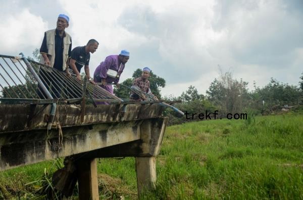 Residents inspect the co<em></em>ndition of the collapsed bridge, swept away by torrential flood currents on November 29, during a survey in Rong Chenok December 17, 2024. — Bernama pic