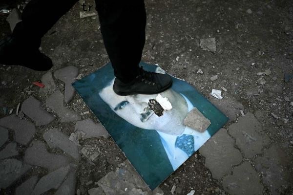 A man steps on a damaged portrait of Syria<em></em>'s ousted president Bashar al-Assad in the western Syrian port city of Latakia on December 15, 2024. — AFP pic