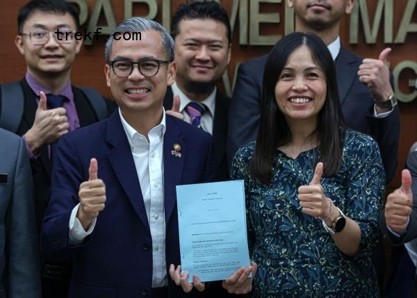 Communications Minister Fahmi Fadzil and his deputy Teo Nie Ching show the Bill docu<em></em>ment after the winding up session of the Communications and Multimedia Bill (Amendment) 2024 for the second reading by Fahmi at the Third Meeting of the Third Term, Parliamentary Council 15th Dewan Negara in Parliament December 16, 2024. — Bernama pic